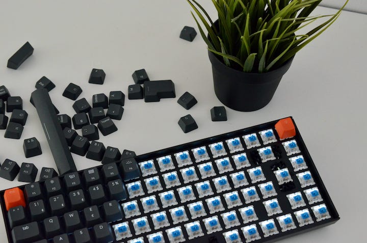 Keychron K2 neben Keycaps und Pflanze